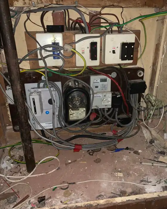 Old meter cupboard with loose wires and old fuse switches